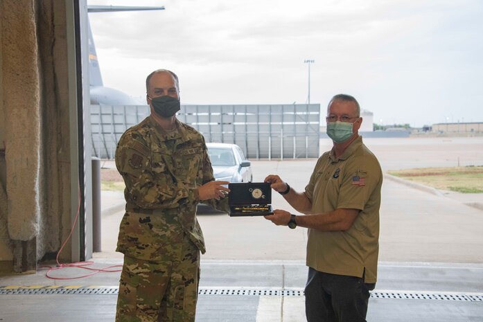 two people hold an award together