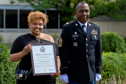 Shani Adams-Houston shows off her spouse certificate of appreciate as she stands next to her husband, Sgt. Maj. Ronald Houston, U.S. Army Financial Management Command Operations senior enlisted advisor, during the sergeant major’s retirement ceremony at the Maj. Gen. Emmett J. Bean Federal Center in Indianapolis July 17, 2020. Sergeant Major Houston retired from the Army after more than 28 years of military service. (U.S. Army photo by Mark R. W. Orders-Woempner)
