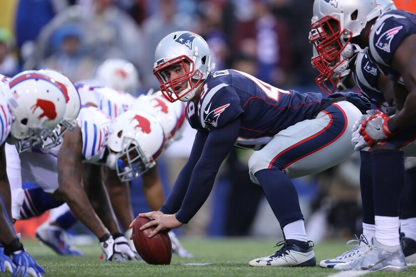 A football player prepares a snap.