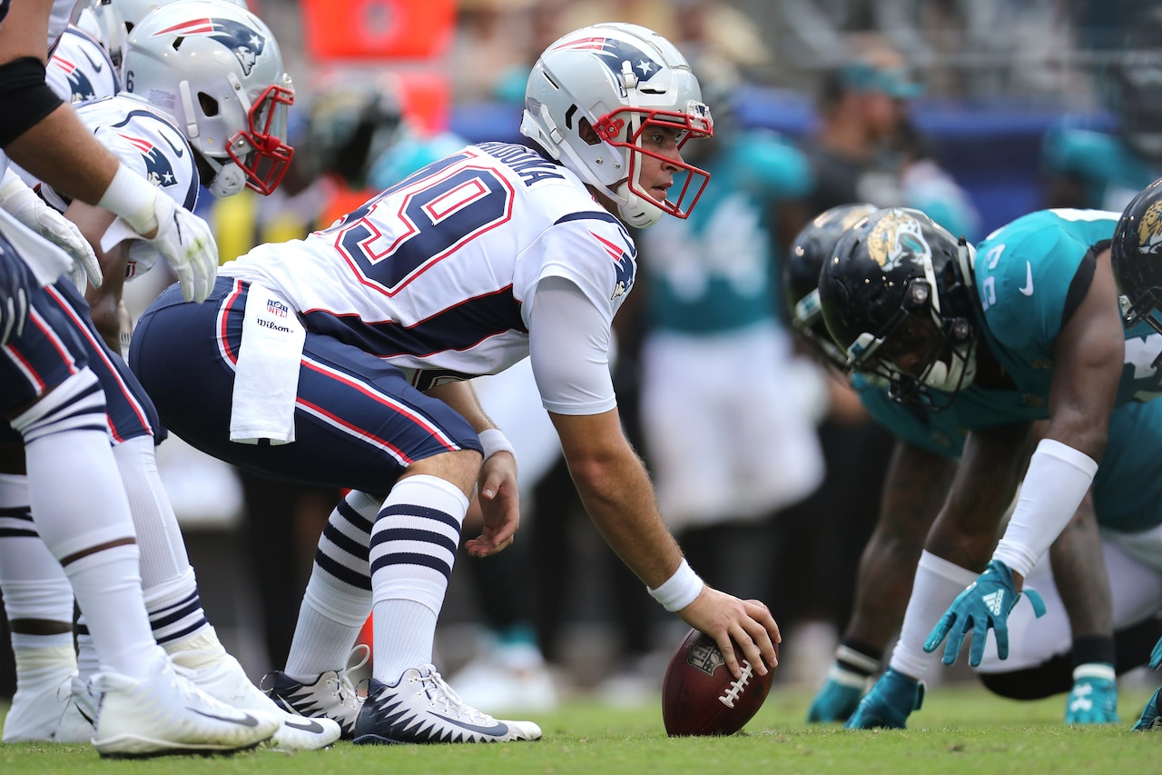 A football player prepares a snap.