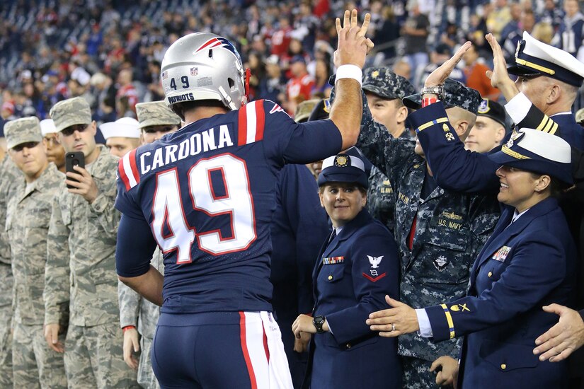 A football player greets fans with high fives.