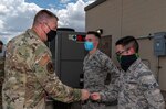 Maj. Gen. William Spangenthal, vice commander of Air Education and Training Command, coins Airman 1st Class Brian Hallock and Airman 1st Class Sebastian Flores, both from the 502nd Operational Support Squadron, during an immersion tour June 24, 2020, at Joint Base San Antonio-Lackland, Texas.