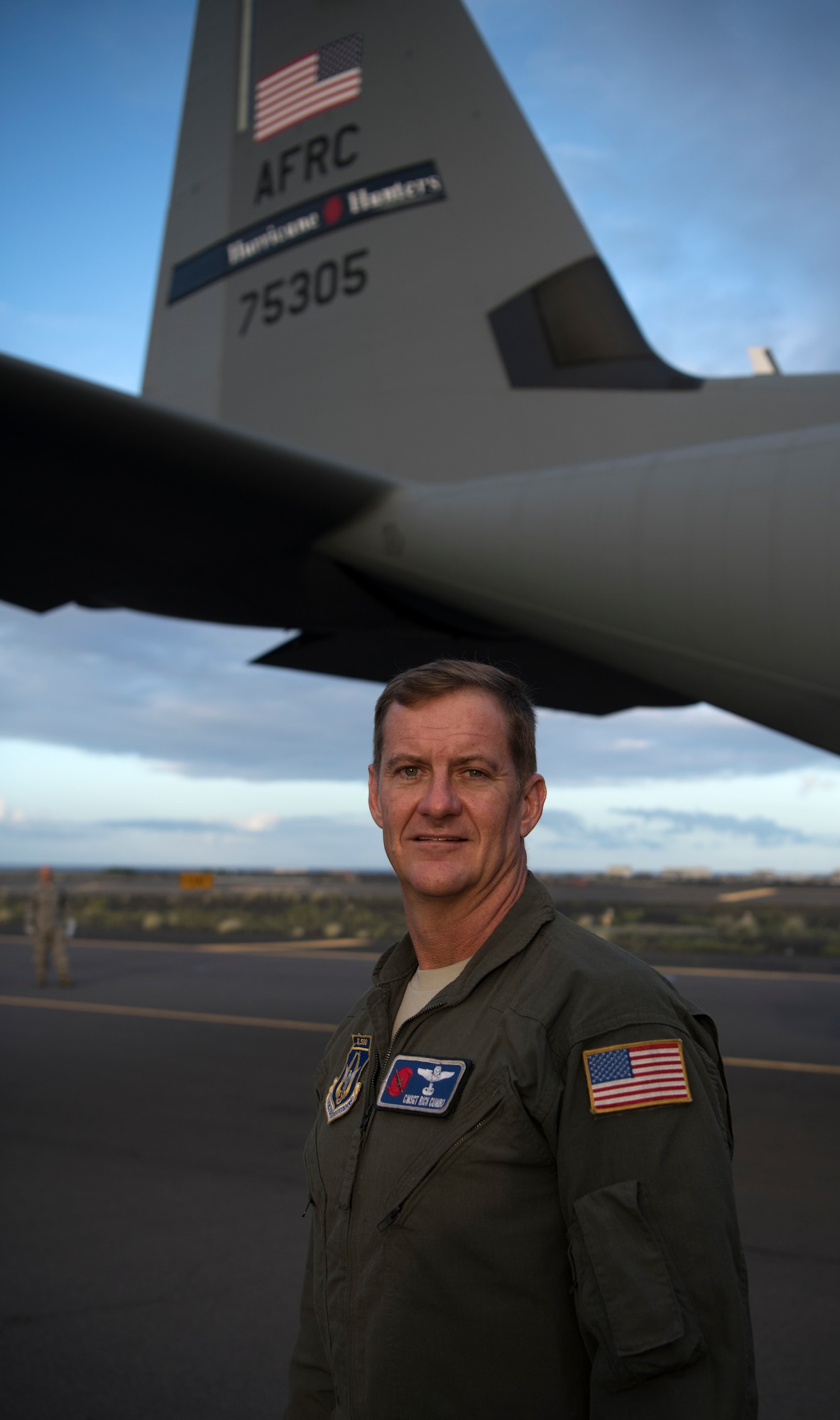 Chief Master Sgt. Rick Cumbo, loadmaster for the 53rd Weather Reconnaissance Squadron at Keesler Air Force Base, Mississippi, stands in front of the tail of a WC-130J Super Hercules at Kona International Airport, Hawaii, July 28, 2020. Cumbo became the recordholder for most eyewall penetrations, with 341, after flying Hurricane Douglas July 24. (U.S. Air Force photo by Senior Airman Kristen Pittman)