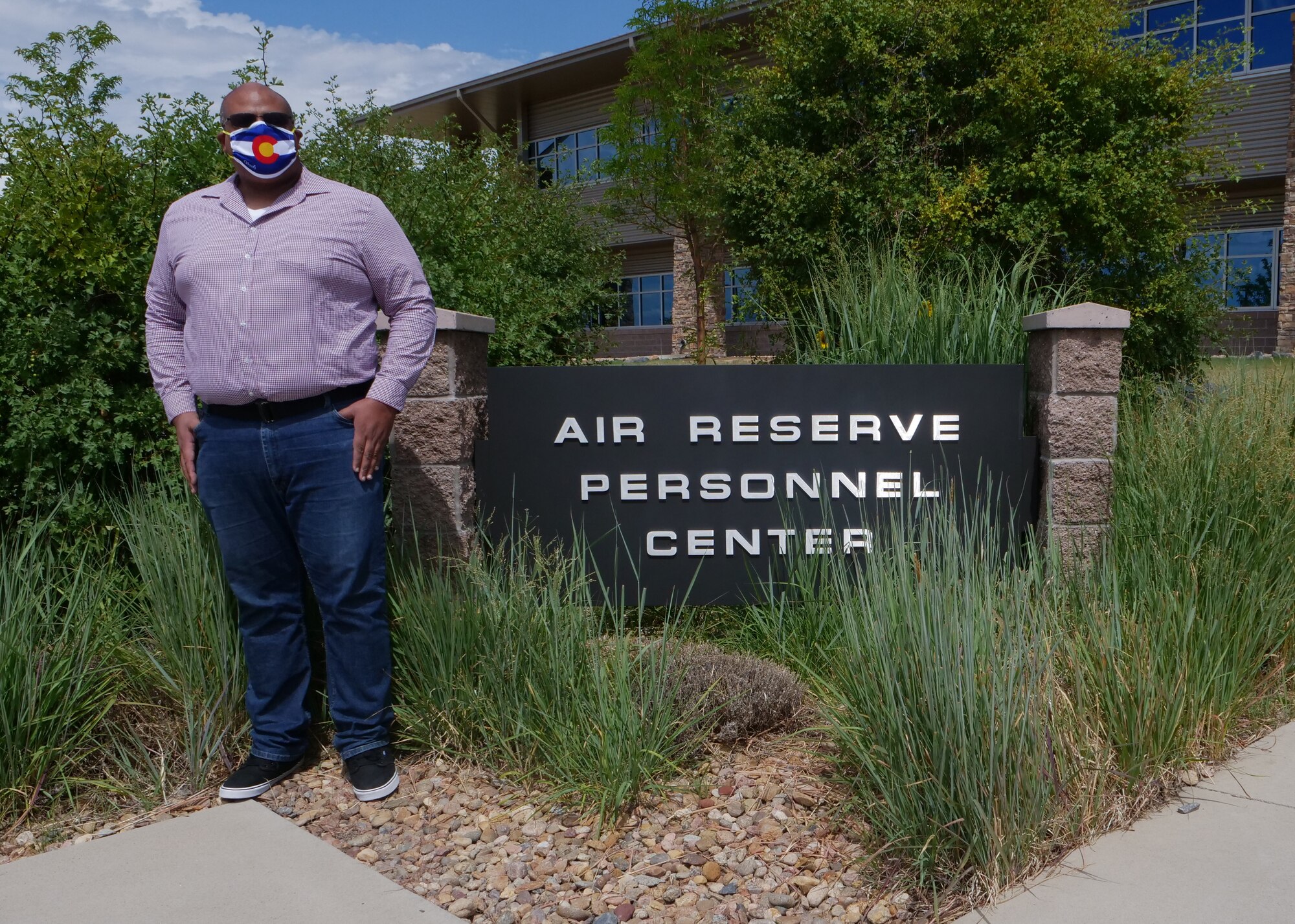 Justin Lozada, a financial management specialist at Headquarters Air Reserve Personnel Center, poses for a photo outside of the building on July 23, 2020, at Buckley Air Force Base, Colorado. Lozada recently began his position and also contracted COVID-19 just before beginning his new job. (U.S. Air Force photo by Master Sgt. Leisa Grant/Released)