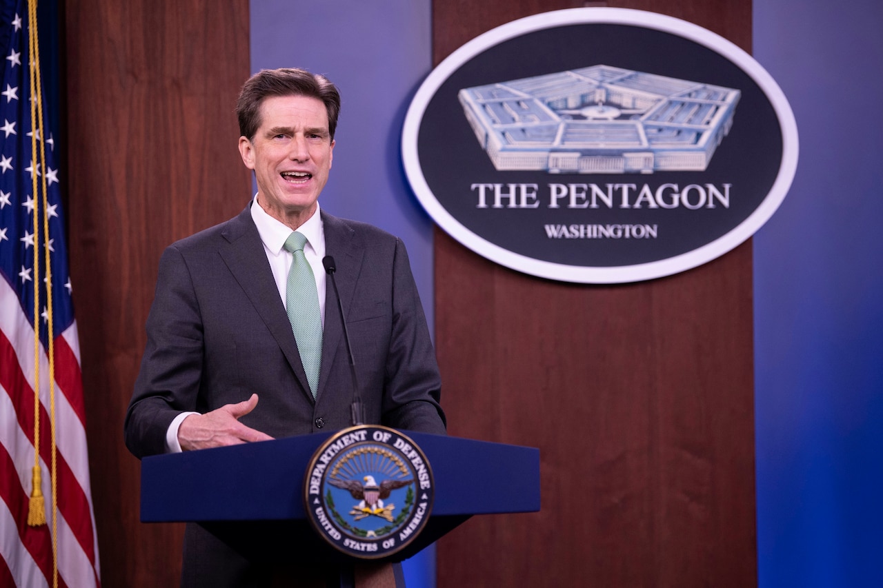 A man stands behind a lectern.