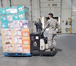 U.S. Air Force Airman 1st Class Nathan Vance, 233rd Space Group, Greeley, Colorado, unloads cases of personal protective equipment at a warehouse in Aurora, Colorado, July 29, 2020. Colorado National Guard Airmen are assisting the Colorado Department of Public Health & Environment with unloading, packaging and distributing PPE to community organizations designated by the state. (U.S. Air National Guard photo by Tech. Sgt. Scottlyn Kibby)