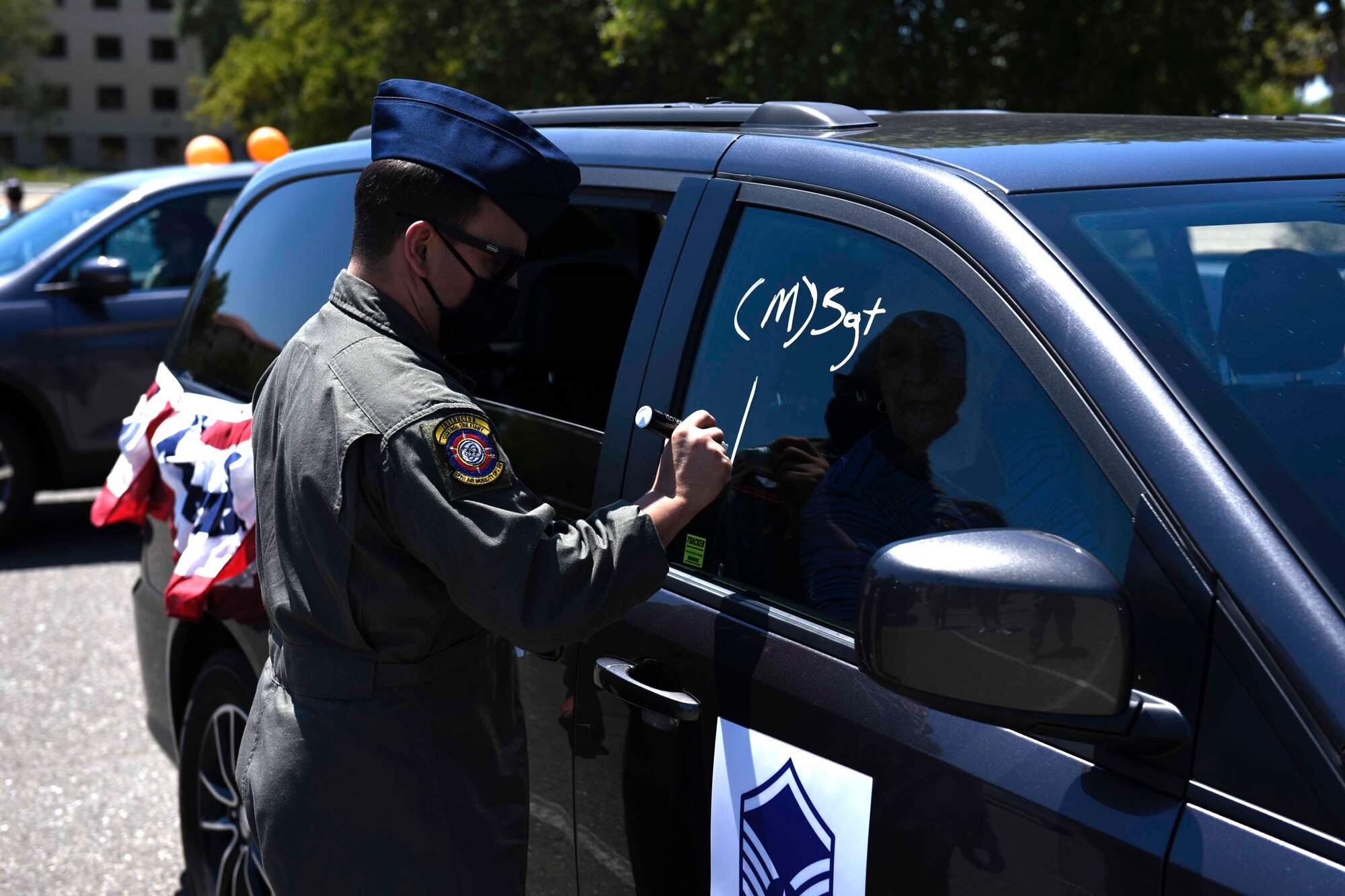 U.S. Air Force Tech. Sgt. Wes Nesting, 321st Air Mobility Operations Squadron aeromedical evacuation controller, decorates his car during a master sergeant release celebration July 23, 2020, at Travis Air Force Base, California. Travis AFB Airmen selected for promotion to master sergeant celebrated by participating in a parade in order to adhere to COVID-19 social distancing guidelines. (U.S. Air Force photo by Airman 1st Class Cameron Otte)