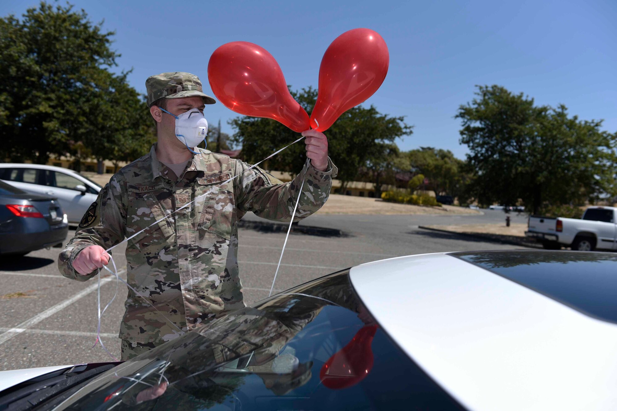U.S. Air Force Tech. Sgt. Nicholas Tkach, 60th Operations Support Squadron aircrew flight equipment non-commissioned officer in charge, decorates his car with balloons during a master sergeant release celebration July 23, 2020, at Travis Air Force Base, California. Travis AFB Airmen selected for promotion to master sergeant celebrated by participating in a parade in order to adhere to COVID-19 social distancing guidelines. (U.S. Air Force photo by Airman 1st Class Cameron Otte)