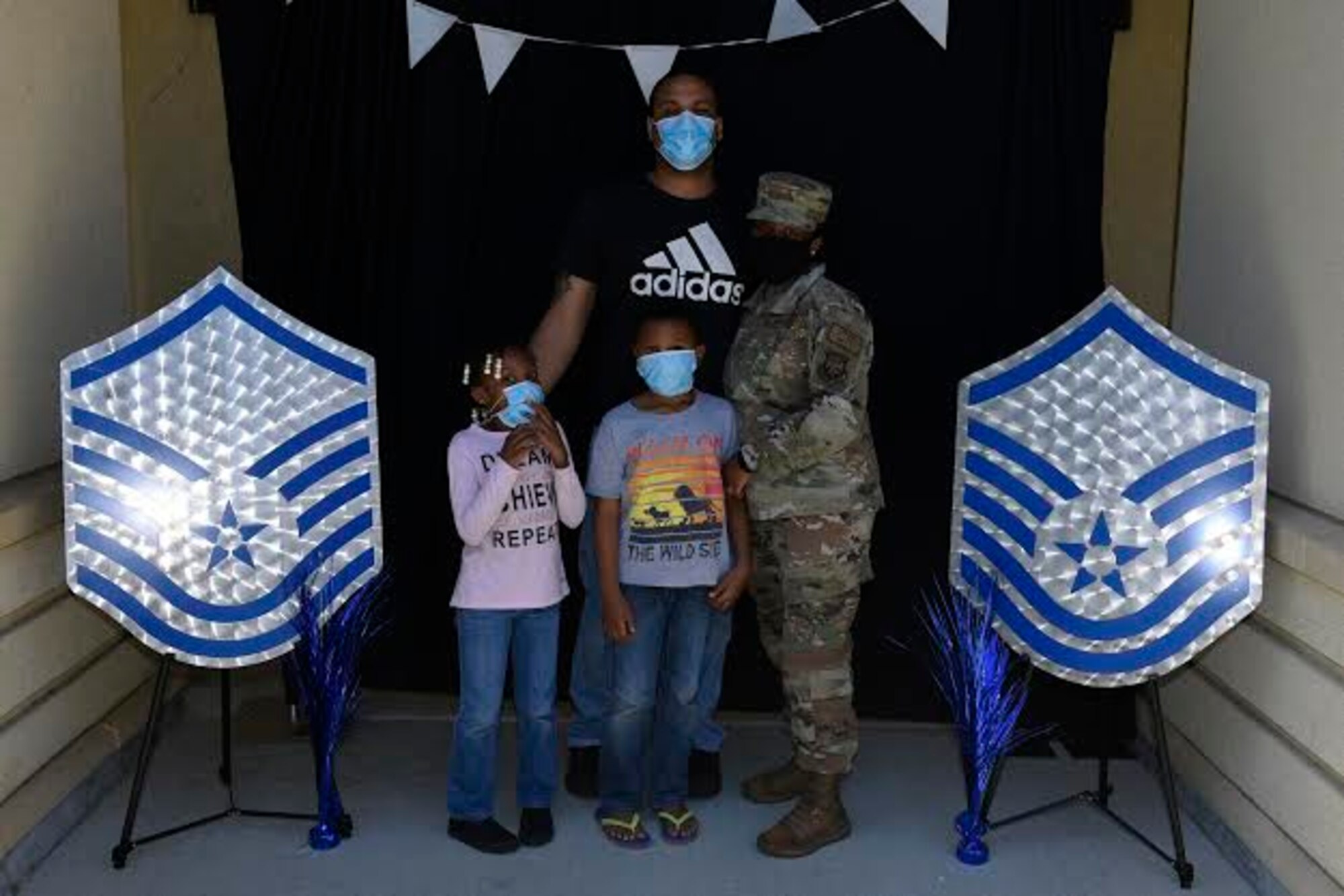 U.S. Air Force Tech. Sgt. Kila Archer, 621st Contingency Response Wing logistics planner, poses for a photo with her family during a master sergeant release celebration July 23, 2020, at Travis Air Force Base, California. The event coordinators created a photo booth for master sergeant selects and their families to take photos. (U.S. Air Force photo by Airman 1st Class Cameron Otte)