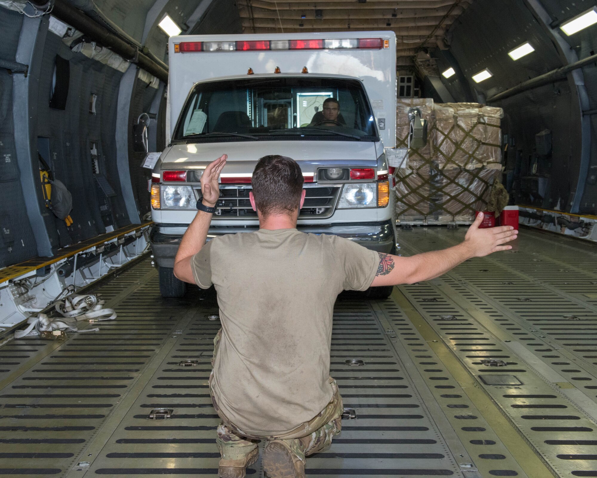 Members of the 30th Aerial Port Squadron, Niagara Falls Air Reserve Station N.Y. and 22nd Airlift Squadron, Travis, Air Force Base, Calif. move equipment inside a C-5 Galaxy aircraft to make way for a fire truck at Niagara Falls ARS on July 25, 2020.  The donated fire truck from Canada and two ambulances will end their long journey in Nicaragua. (U.S. Air Force photo by Peter Borys)