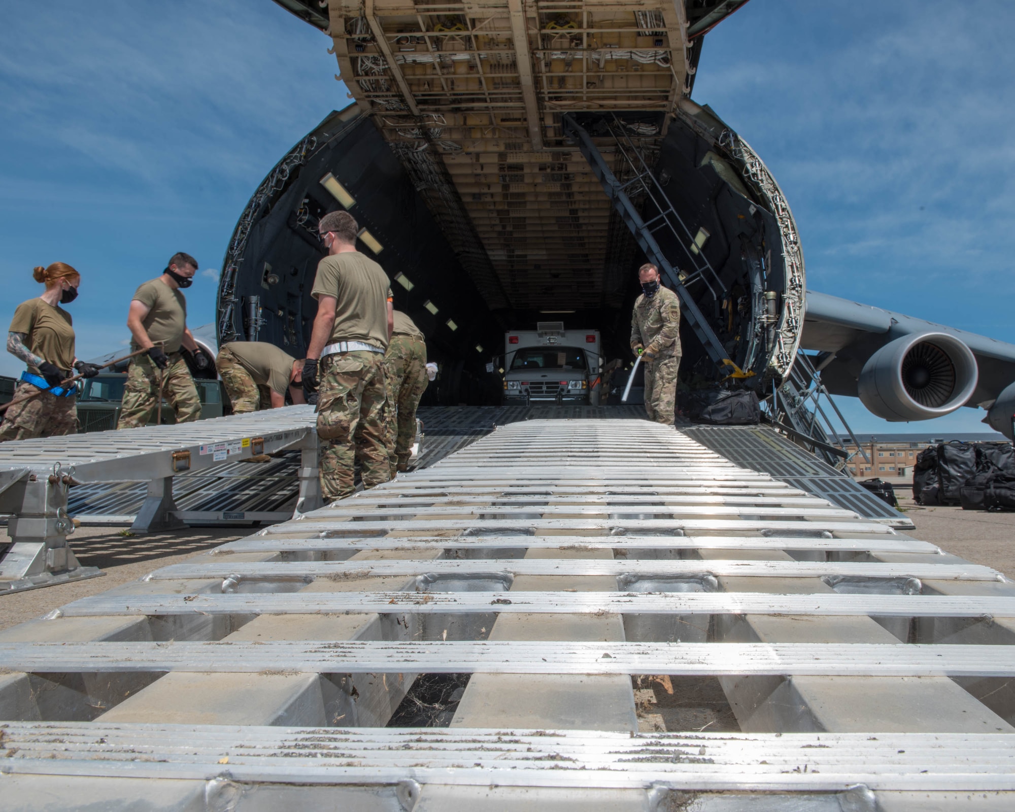 U.S. Airmen assigned to the 30th Aerial Port Squadron, Niagara Falls Air Reserve Station New York and the 22nd Airlift Squadron, Travis Air Force Base, California move equipment inside a C-5M Super Galaxy at Niagara Falls Air Reserve Station, New York, July 25, 2020. The aircrew transported humanitarian aid, to include a fire truck and ambulance, to Nicaragua. (U.S. Air Force photo by Peter Borys)
