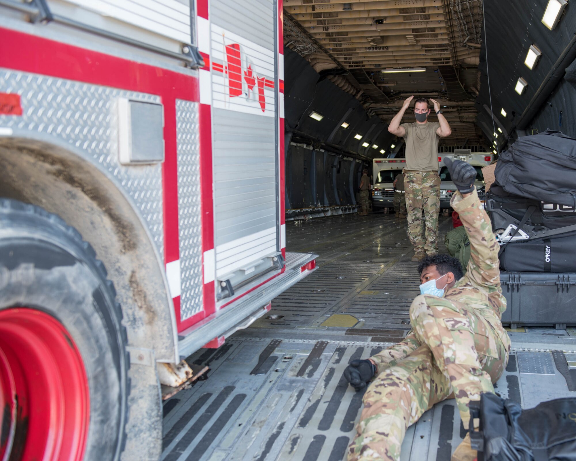 U.S. Airmen assigned to the 30th Aerial Port Squadron, Niagara Falls Air Reserve Station New York and the 22nd Airlift Squadron, Travis Air Force Base, California load a fire truck inside a C-5M Super Galaxy at Niagara Falls Air Reserve Station, New York, July 25, 2020. The aircrew transported humanitarian aid, to include a fire truck and ambulance to Nicaragua. (U.S. Air Force photo by Peter Borys)