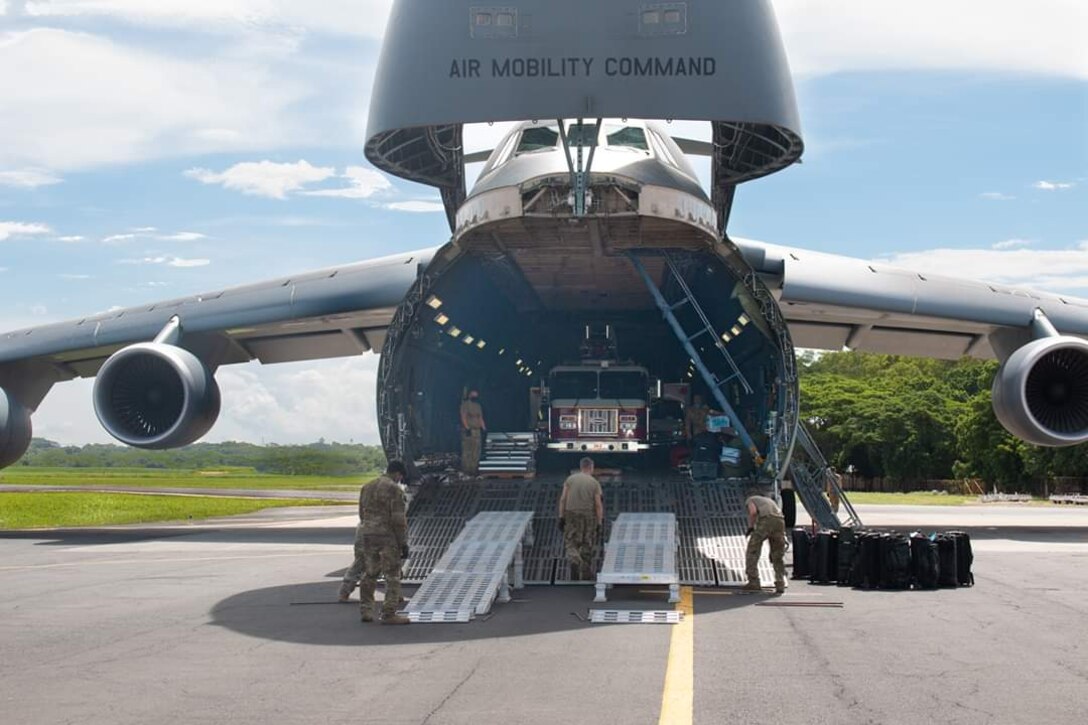 U.S. Airmen assigned to 22nd Airlift Squadron, Travis Air Force Base, California, unload cargo from a C-5M Super Galaxy in support of a Denton Program mission July 26, 2020, at Managua, Nicaragua. The aircrew delivered a fire truck, ambulance, furniture, sewing material, agricultural supplies and educational material to Nicaragua. (Courtesy photo)