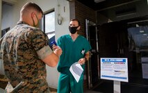 U.S. Navy Hospital Corpsman Petty Officer 2nd Class Patrick O’Connor, with Combat Logistics Regiment 37, takes the temperature and asks screening questions regarding possible exposure to COVID-19 to all personnel that walk into the Camp Kinser Evans Dental Clinic, in support of Health Protection Conditions July 29, 2020.