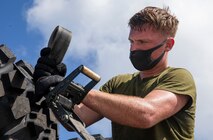 U.S Marine Corps Lance Cpl. Benjamin Boles, a motor transport operator with 3rd Marine Logistics Group, wears a face covering in support of Health Protection Conditions, as he prepares gear for delivery on Camp Kinser, Okinawa, July 29, 2020.