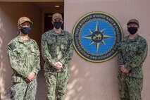 200625-N-IO414-1033 NAVAL SUPPORT ACTIVITY BAHRAIN (June 25, 2020) Ensign Jonathon Deering, left, Ensign Conor O’Donnell, center, and Ensign Michael Petty pose for a photo in front of U.S. Naval Forces Central Command’s Naval Cooperation and Guidance for Shipping (NCAGS) headquarters. NCAGS serves as a communication link between merchant and military vessels and is made up entirely of U.S. Navy reservists, many of whom are professional merchant marines who leverage their civilian expertise and experience when they report for duty.
