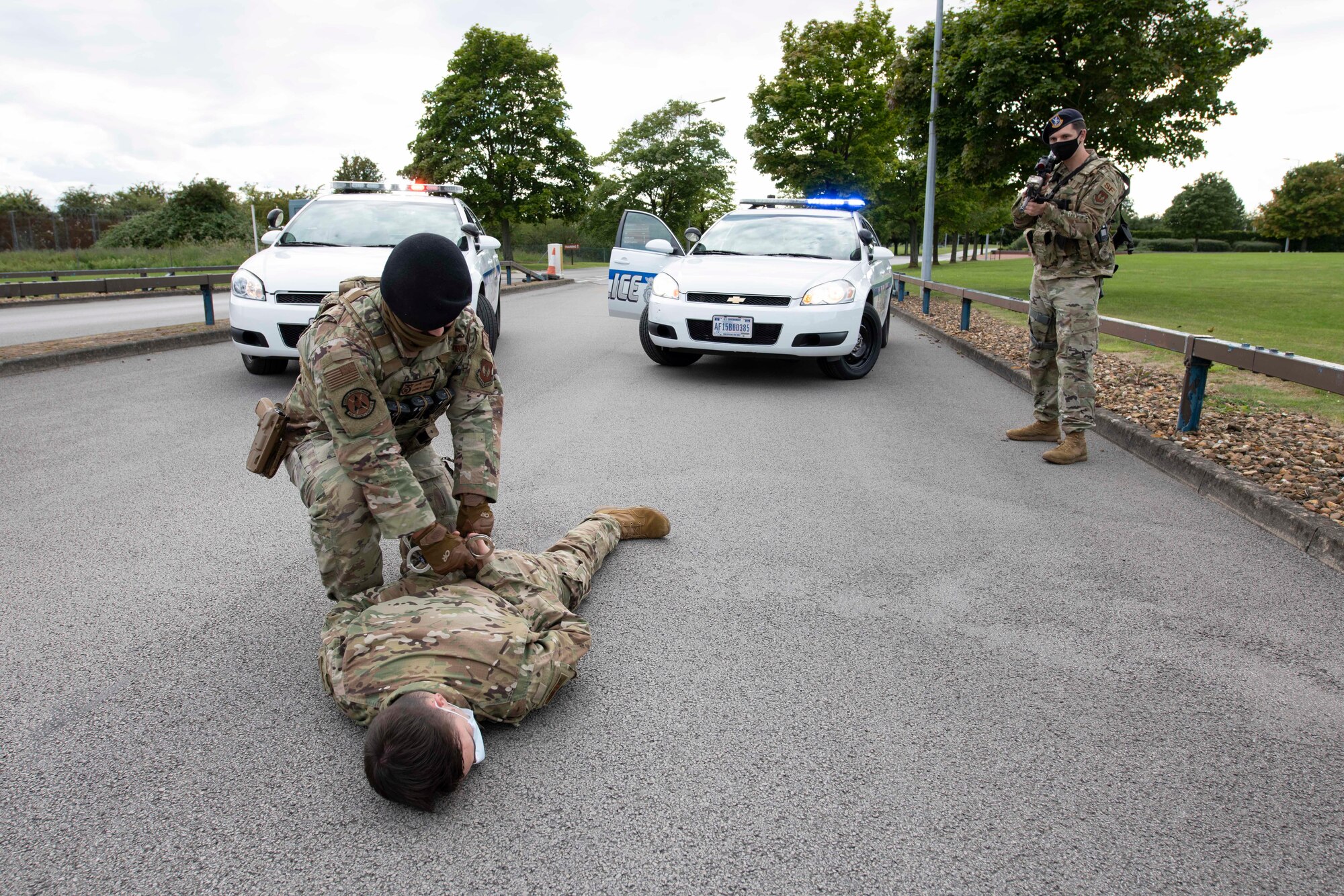 U.S. Air Force Senior Airman Josten Lacey and Staff Sgt. Derek Ricks, 423rd Security Forces Squadron (SFS) patrolmen, demonstrates apprehension techniques during a simulated gate runner and high risk vehicle challenge training at RAF Molesworth, England, July 28, 2020. 423rd SFS defenders conduct regular training and exercises to ensure mission readiness. (U.S. Air Force photo by Airman 1st Class Jennifer Zima)