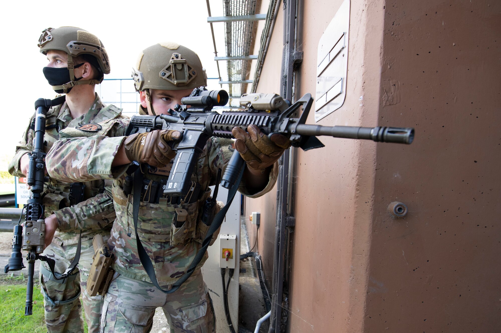 U.S. Air Force Staff Sgt. Derek Ricks, left, and Senior Airman Josten Lacey, right, 423rd Security Forces Squadron (SFS) patrolmen, clear a building during a simulated active shooter training at RAF Molesworth, England, July 28, 2020. 423rd SFS defenders conduct regular training and exercises to ensure mission readiness. (U.S. Air Force photo by Airman 1st Class Jennifer Zima)