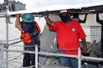 Dustin Spitler (left), Shop 89 mechanic, and Carlos Ellis, Shop 89 shipwright supervisor, installs a scaffold on the vertical launch platform onboard Virginia class submarine, USS New Mexico (SSN 779).