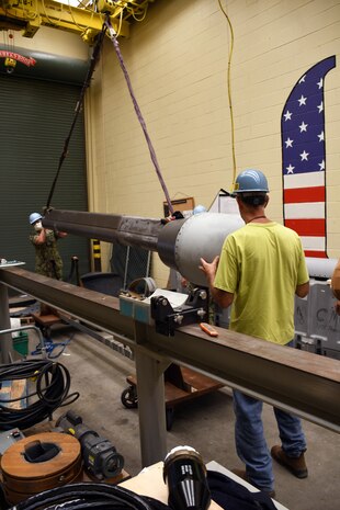 Shop 67HS’s Machinist Mate Second Class Derek Boulanger (left) and Shop 38’s Outside Machinist Tim Porter prepares a high data rate antenna for transport to the Virginia class submarine USS Washington (SSN 787).