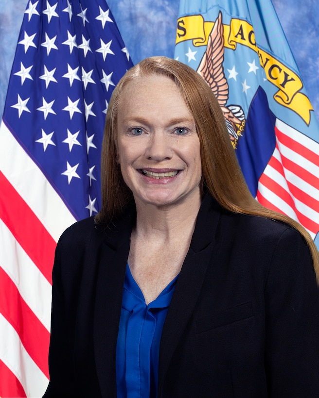 official photo of Stacey Pilling with American flag and DLA flag in background.