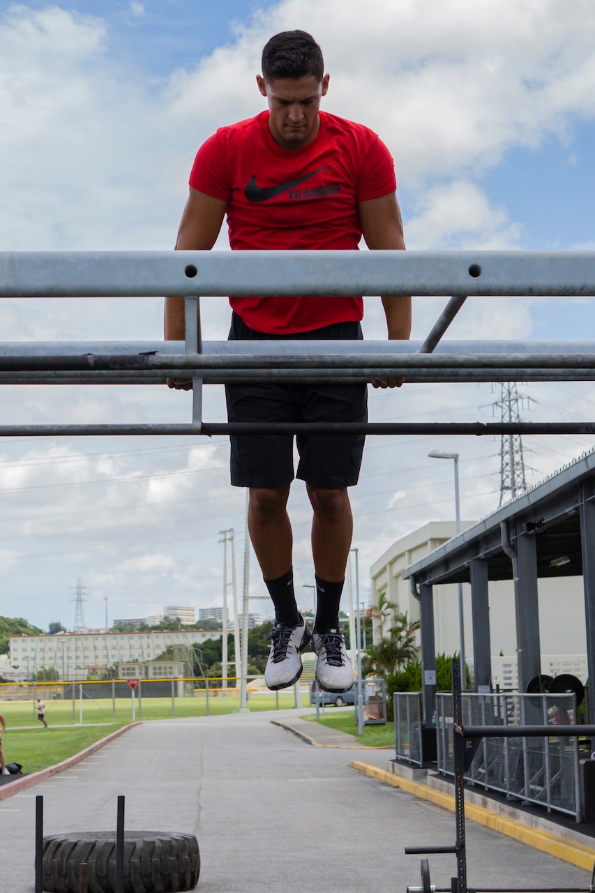 A man pushes up over a bar during exercise.