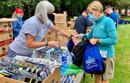 Camp Rosenbaum staff members Shelly Davison (left) helps Connie Opsal, Camp Rosenbaum Camp Director (right) fill backpacks for Operation Lemonade, in Portland, Ore., June 27, 2020.