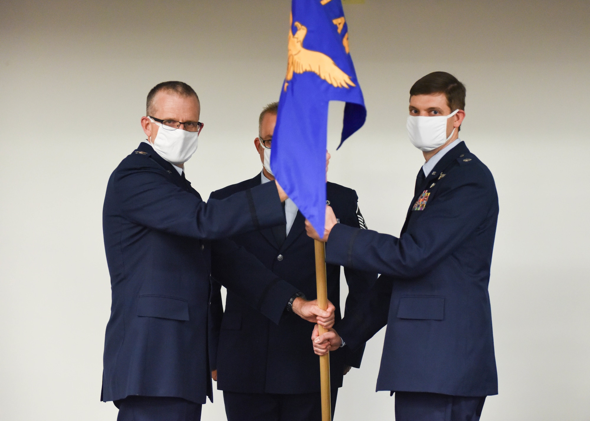 Lt. Col. Christopher Kurpiel, 911th Operations Support Squadron commander,  receives the 911th OSS guidon from Col. Gregory Buchanan, 911th Operations Group commander, during a change of command ceremony at the Pittsburgh International Airport Air Reserve Station, Pennsylvania, July 11, 2020.