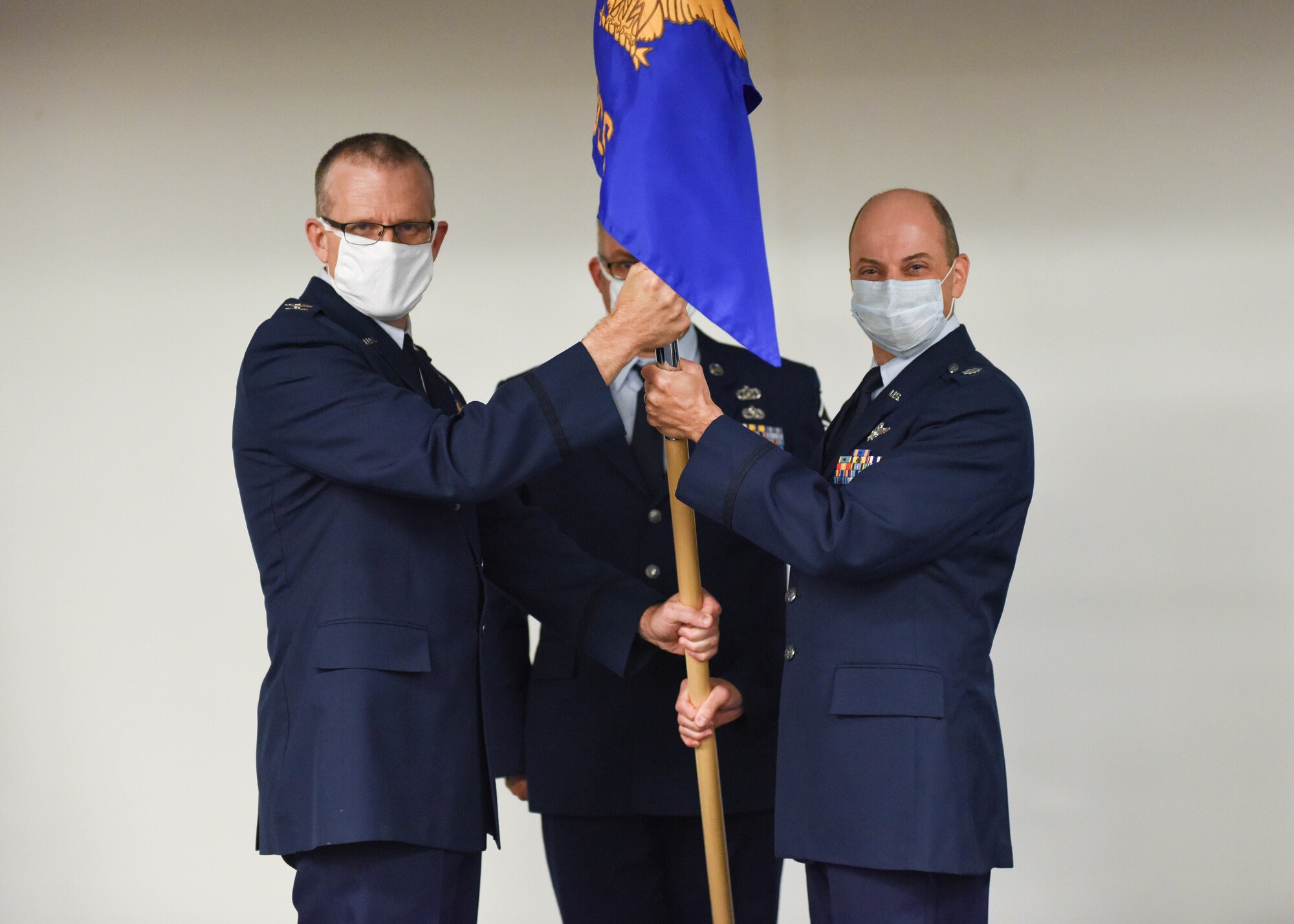 Lt. Col. Christian Constantine, former 911th Operational Support Squadron commander,  passes the 911th OSS guidon to Col. Gregory Buchanan, 911th Operations Group commander, during a change of command ceremony at the Pittsburgh International Airport Air Reserve Station, Pennsylvania, July 11, 2020.