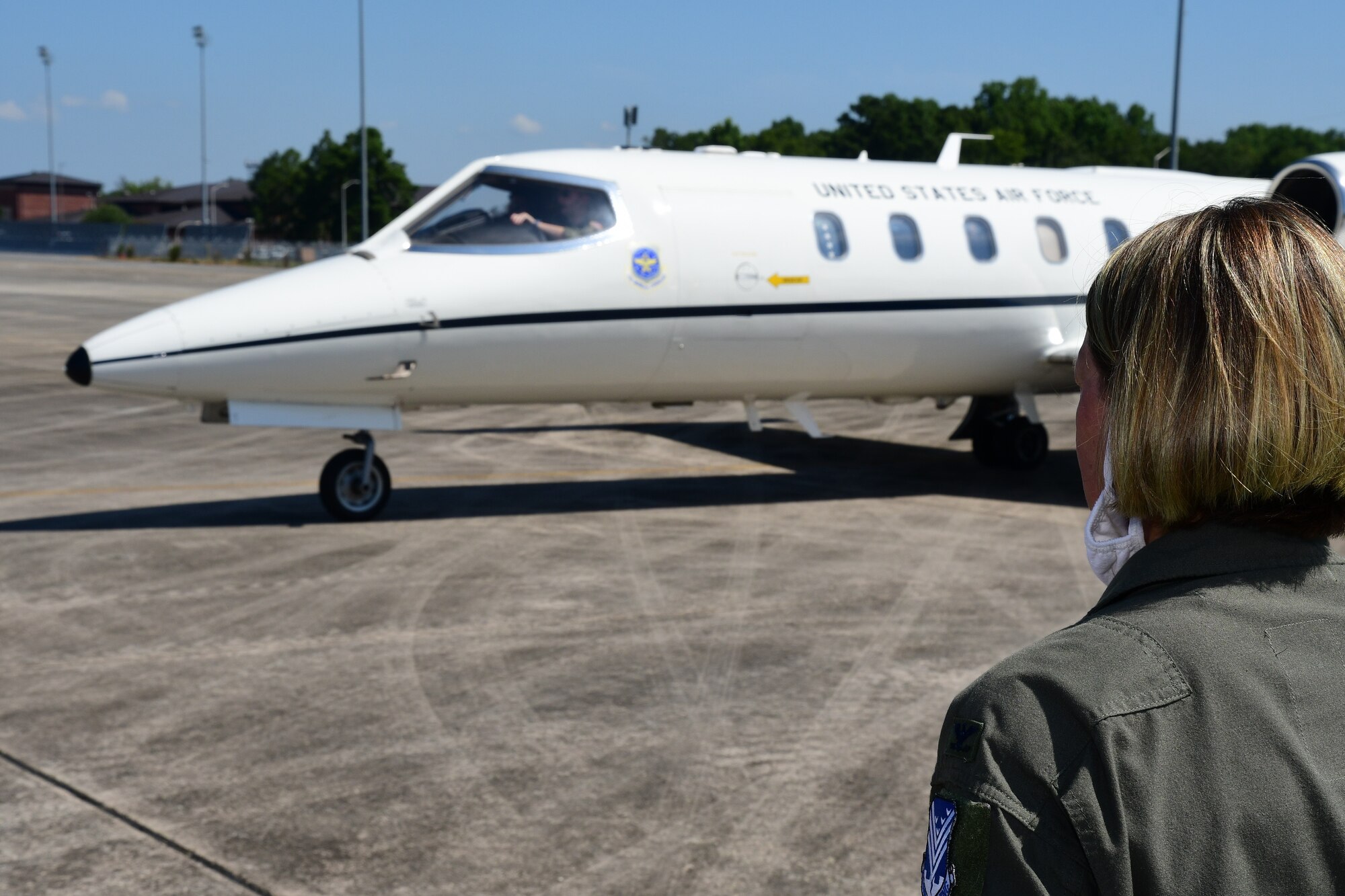 U.S. Air Force Col. Amy Holbeck, 116th Air Control Wing commander, Georgia Air National Guard, watches on as Gen. Mike Holmes, commander of Air Combat Command, arrives at Robins Air Force Base, Georgia, July 20, 2020. Holmes is responsible for organizing, training, equipping and maintaining combat-ready air, space, cyber and intelligence forces for rapid deployment and employment while ensuring strategic air defense forces are ready to meet the challenges of peacetime air sovereignty and wartime defense. (U.S. Air National Guard photo by Barry Bena)