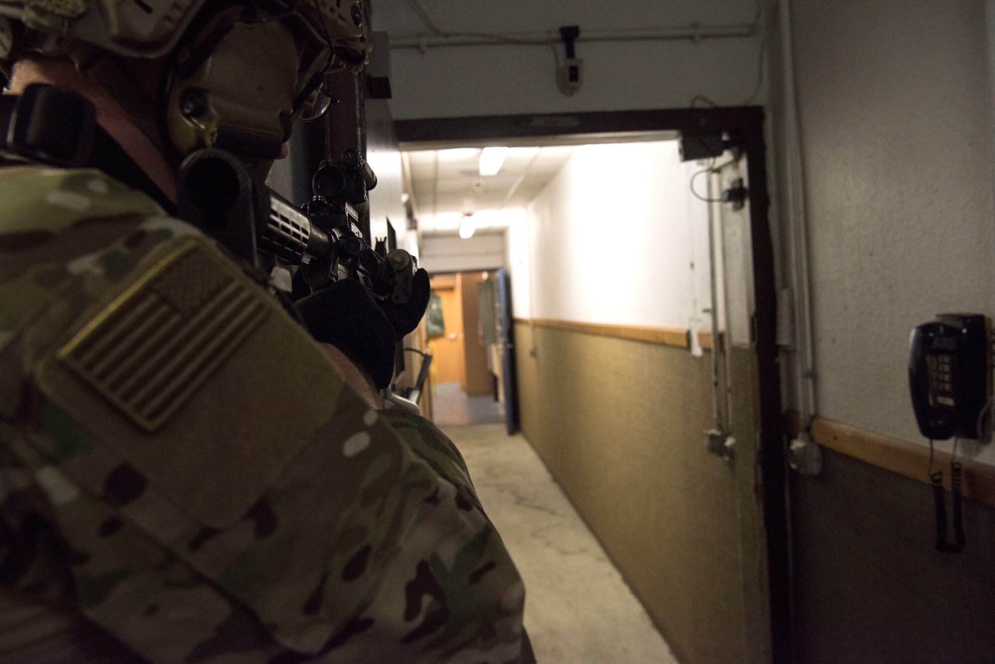 A U.S. Air Force Airman assigned to the 435th Security Forces Squadron aims his M-4 Carbine rifle down a hall during close quarters battle training.