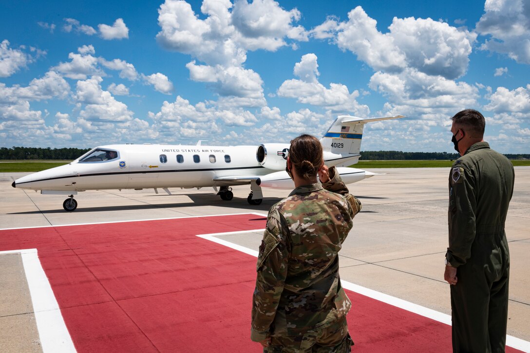 A photo of wing commanders saluting an aircraft