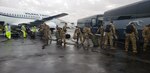 Soldiers board aircraft.