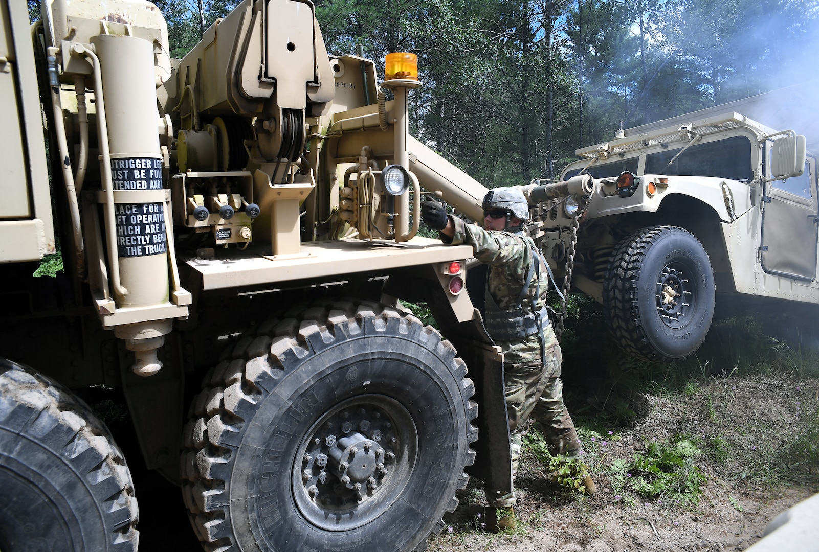 Spc. Darrin Hilts, a wheeled vehicle mechanic with the Michigan Army National Guard's 1073rd Maintenance Company,  works the hydraulics of an M984 HEMTT wrecker while preparing to tow a Humvee as part of a training mission during exercise Northern Strike at Camp Grayling, Michigan, July 27, 2020.