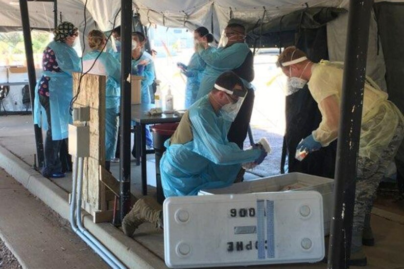 Guardsmen in protective gear work together.