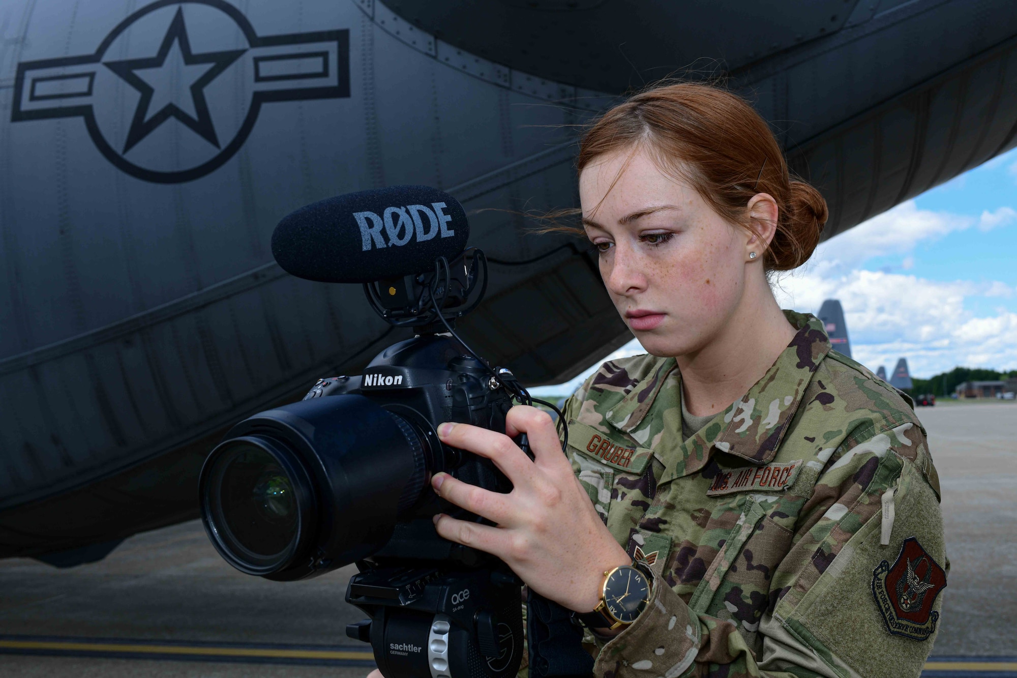 Senior Airman Sarah Jane Gruber, a broadcast journalist for the 910th AW,  checks her camera settings on the Youngstown Air Reserve Station's flightline. Broadcast journalists are responsible for ethically documenting the wings mission and producing visual information products in order to tell the Air Force Story.