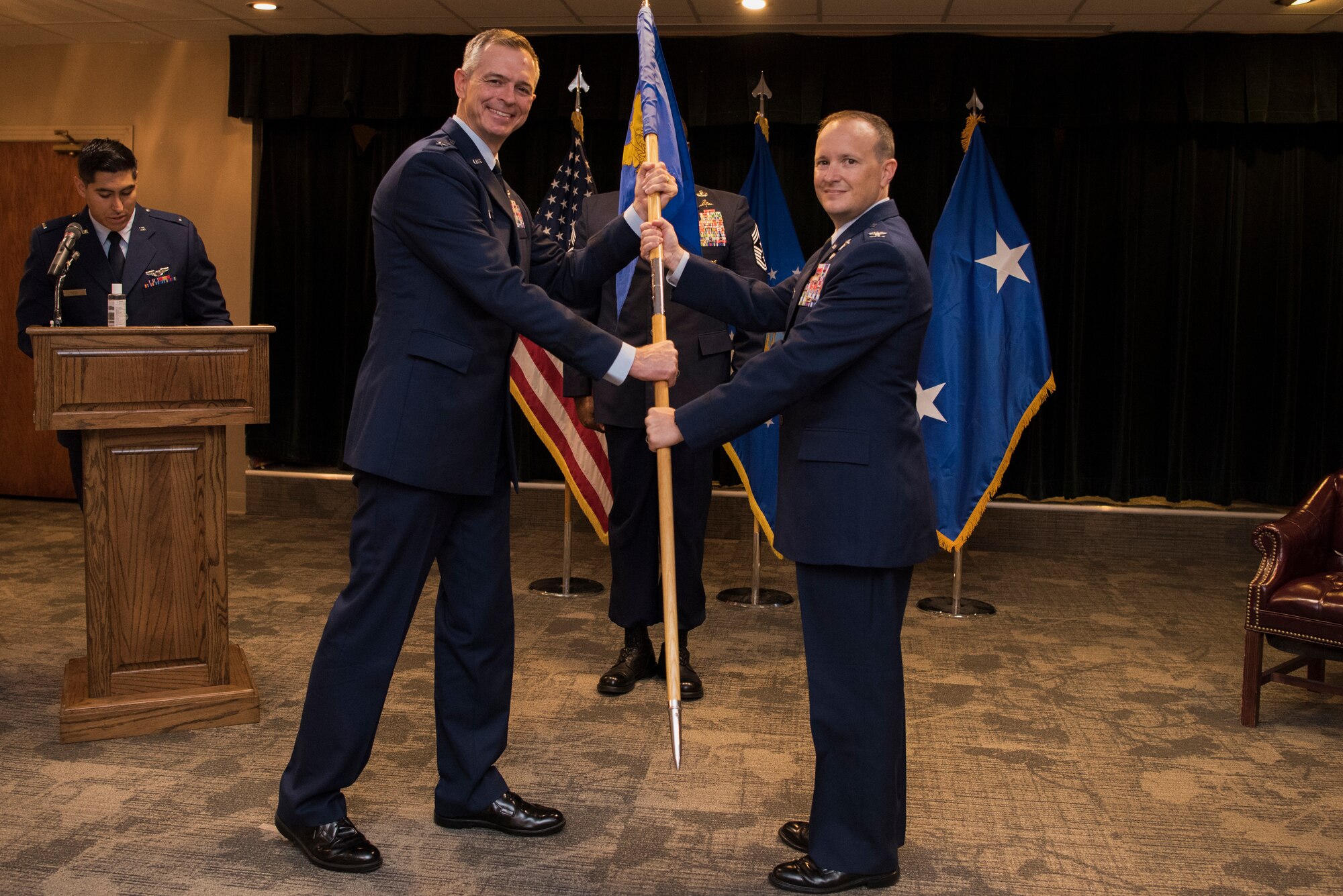 Maj. Gen. Craig Wills, 19th Air Force commander, passes the guidon to Col. Craig D. Prather, 47th Flying Training Wing commander, during the virtual wing change of command ceremony at Laughlin Air Force Base, Texas, July 31, 2020. Prather takes command after serving as the commander of the 1st Joint Special Operations Air Component at Fort Bragg, N.C. (U.S. Air Force photo by Senior Airman Marco A. Gomez)