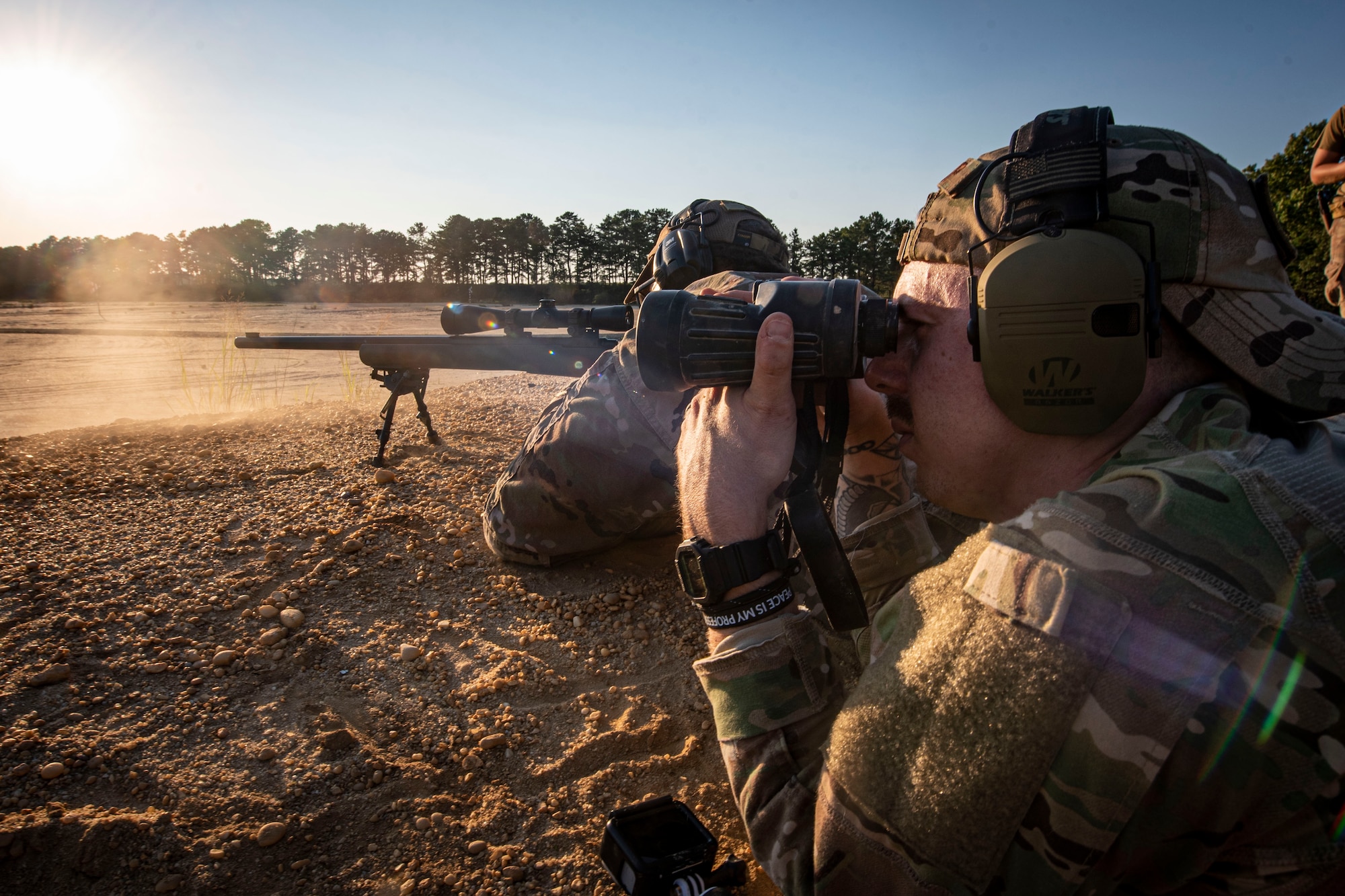 Photo of an Airman spotting for another during an M24 sniper rifle qualification and proficiency firing training session.