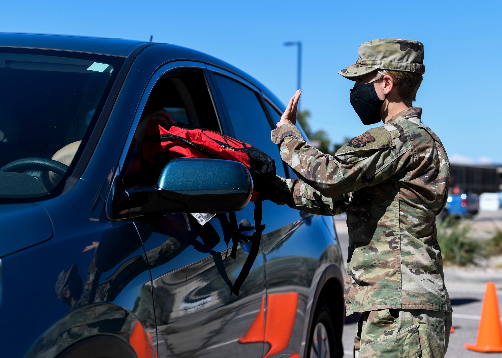 An Airman hands out school supplies.