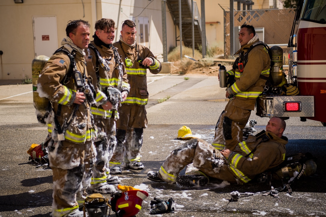 Firefighters from the Edwards Air Force Base Fire and Emergency Services take a break following search and rescue training at a recently remodeled hangar at Edwards Air Force Base, California, July 23. Firefighters were tasked with locating a simulated victim amidst the fire suppressant foam deployed throughout the hangar. (Air Force photo by Chris Dyer)