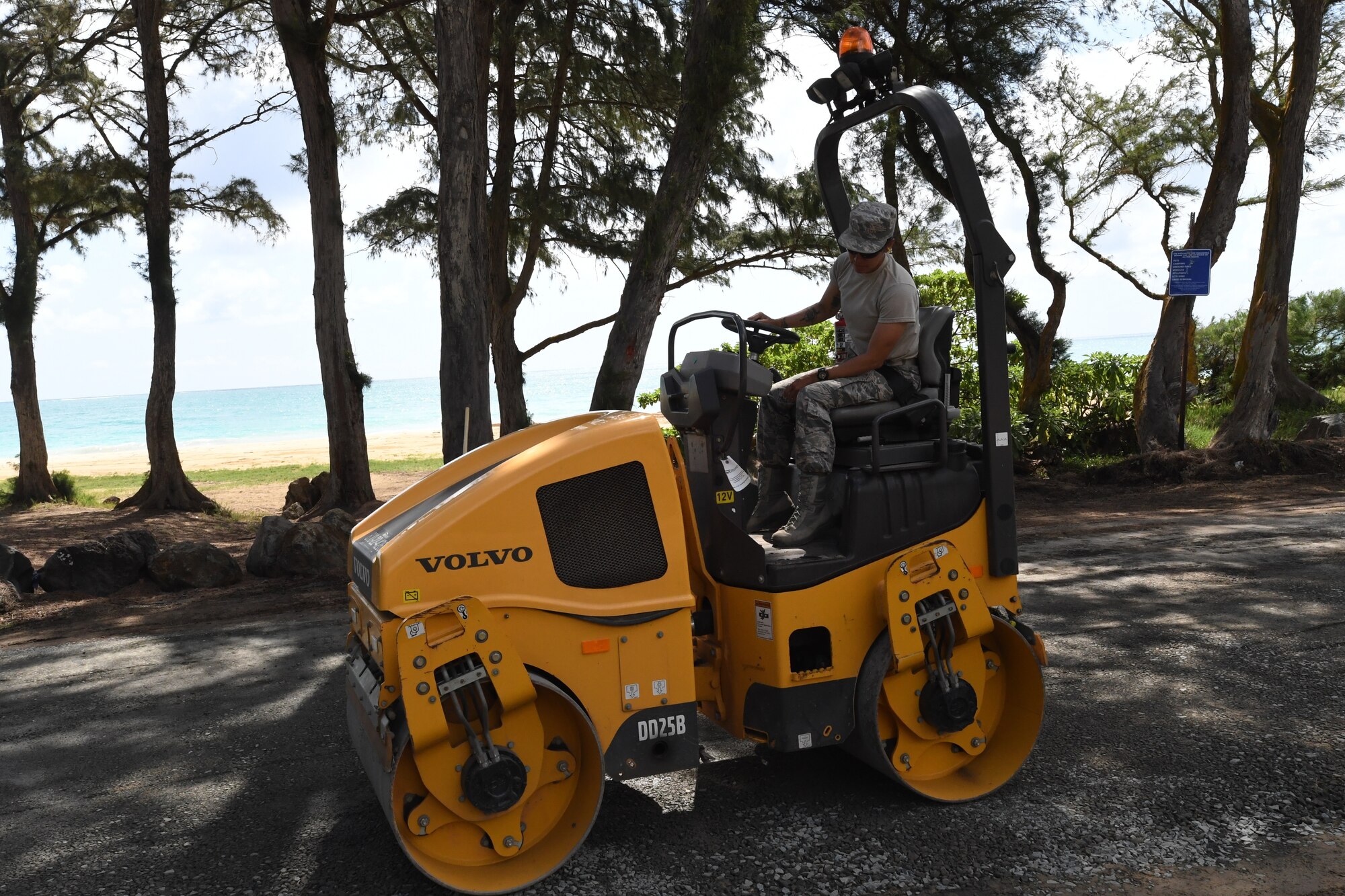 A photo of U.S. Air Force Senior Airman Pleiades Dolor, 624th Civil Engineer Squadron heavy equipment specialist, leveling the ground in preparation for pavement repairs at Bellows Air Force Station, Hawaii, July 22, 2020, during the unit’s Annual Training. The U.S. Air Force Reserve’s 624th CES provided necessary repairs at Bellows AFS, a Military Welfare and Recreation facility that supports military families and communities, to improve infrastructure and increase individual readiness skills. (U.S. Air Force photo by Tech. Sgt. Garrett Cole)