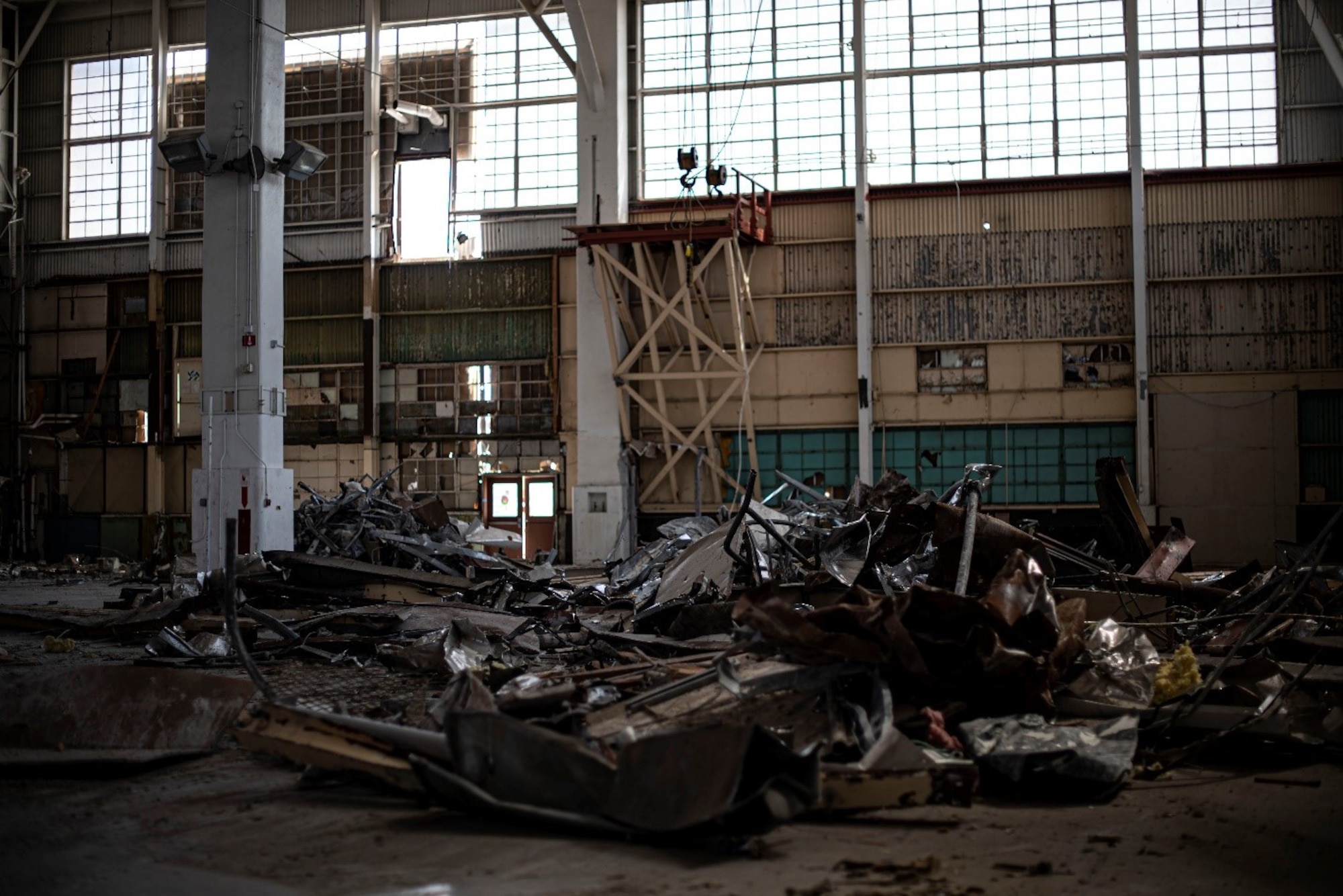 Scrap metal and rubbish sits in the middle of a bombed-out-looking building