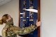 Airman 1st Class Alexandria, force management technician with the 432nd Support Squadron, carefully places a command board on the wall of the newly renovated consolidated support center at Creech Air Force Base.