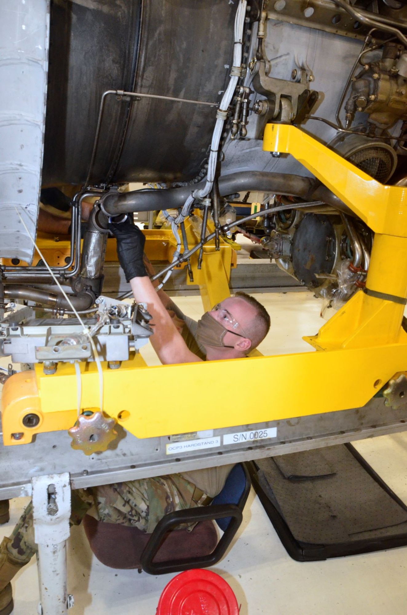 Photo of maintenance personnel installing an engine part