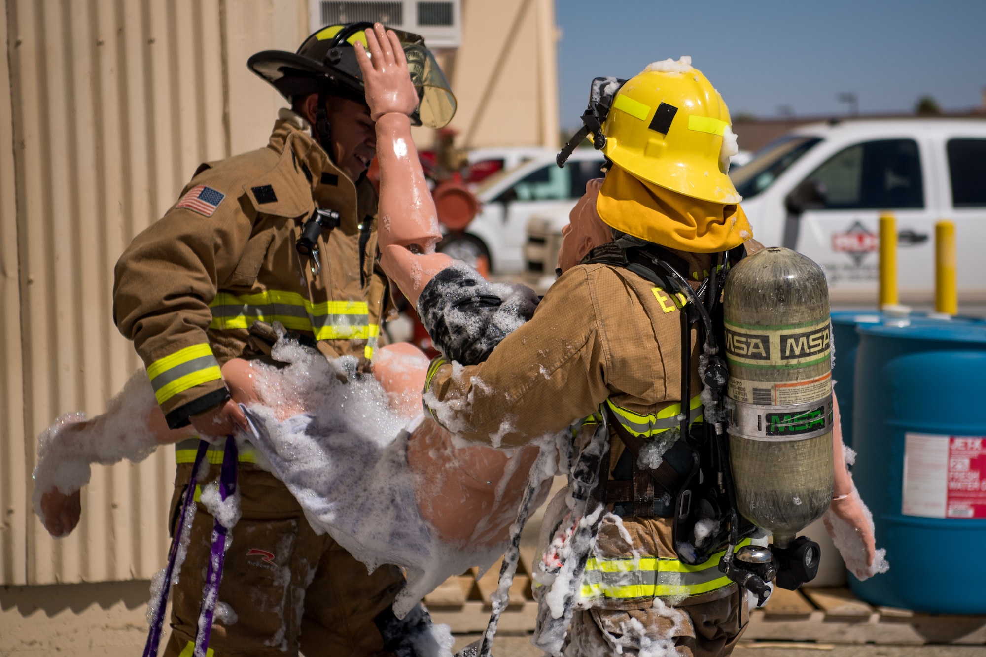 Firefighters Senior Airman Rene Rosas and Brody Deal evacuate a simulated victim during search and rescue training at a recently remodeled hangar at Edwards Air Force Base, California, July 23. The unique training opportunity provided the firefighters a mentally and physically demanding training scenario. (Air Force photo by Chris Dyer)