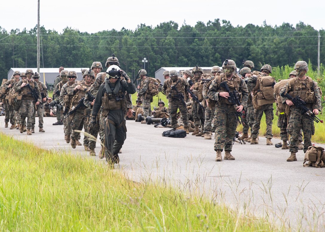 A crew chief with Marine Heavy Helicopter Squadron 366, 2nd Marine Aircraft Wing, leads Marines with 3rd Battalion, 6th Marine Regiment to board a CH-53E Super Stallion during Exercise Deep Water 2020 at Marine Corps Air Station New River, N.C., July 29, 2020. The purpose of the exercise is to increase 2nd Marine Aircraft Wing’s interoperability and readiness on a scale that simulates peer-level threats. (U.S. Marine Corps photo by Lance Cpl. Yuritzy Gomez)