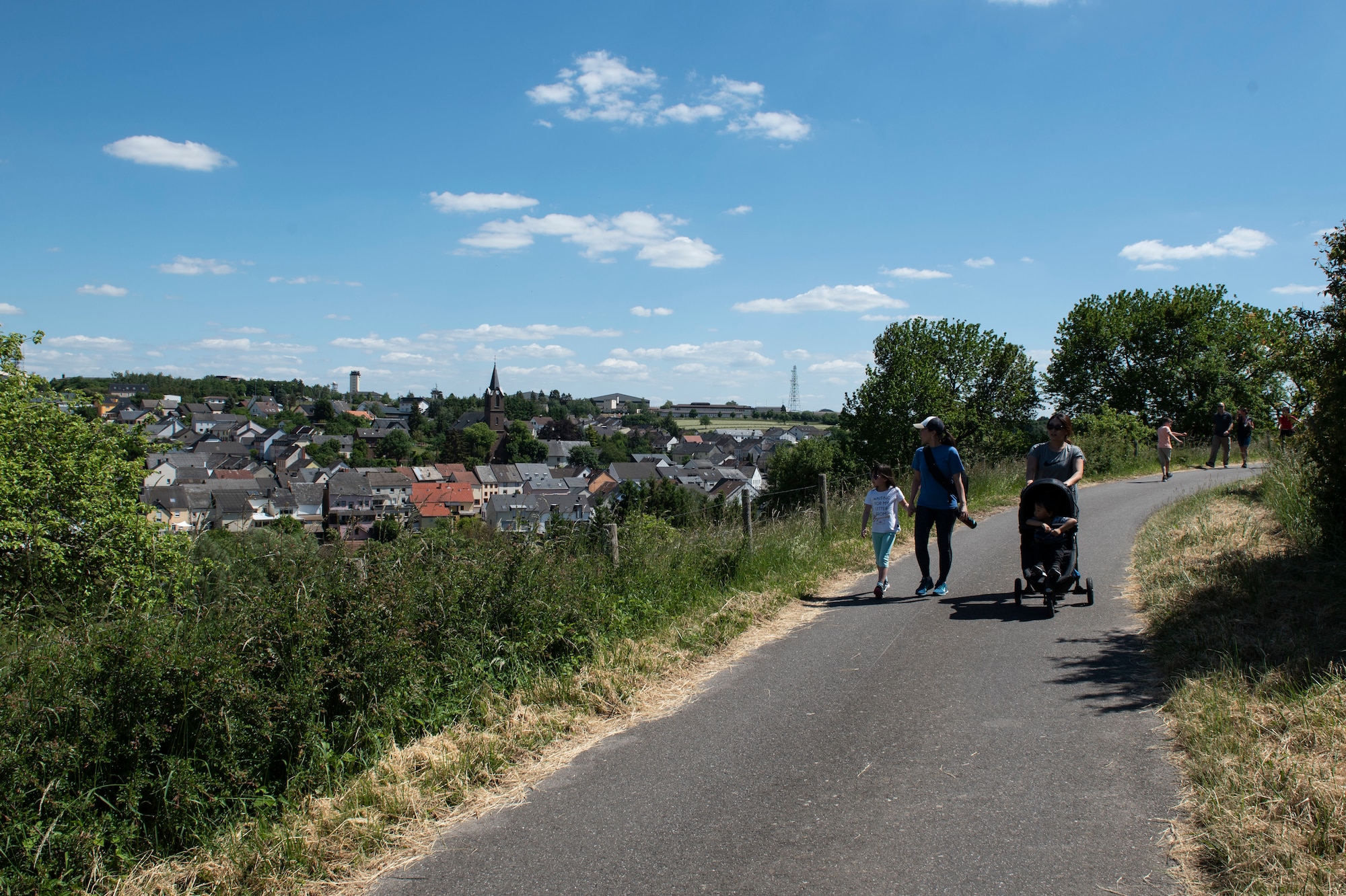 Spangdahlem Air Base families look at the view of the town while participating in a six-kilometer walk around the village of Spangdahlem, Germany, May 29, 2020. To ensure the safety of all participating during the COVID-19 pandemic, the walk allowed more physical distancing measures and participants were able to see different historical sites that had frequent views over the surrounding villages. (U.S. Air Force photo by Senior Airman Melody W. Howley)