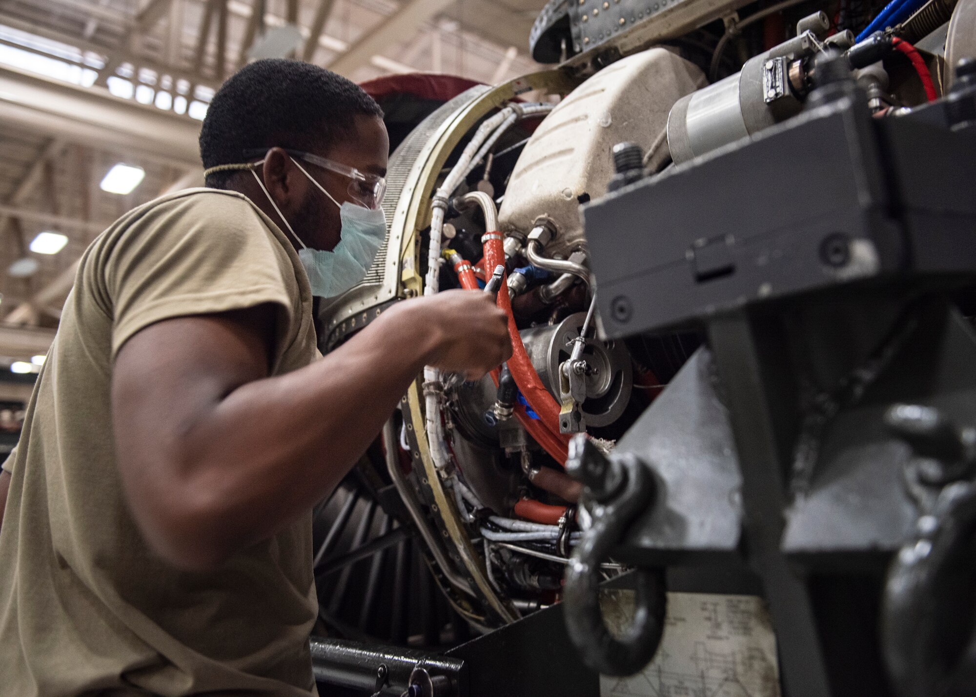 A 361st Training Squadron aerospace propulsion student wears a mask during training as precautions for the COVID-19 virus at Sheppard Air Force Base, Texas, June 1, 2020. The student is working on an aircraft engine. (U.S. Air Force photo by Senior Airman Pedro Tenorio)