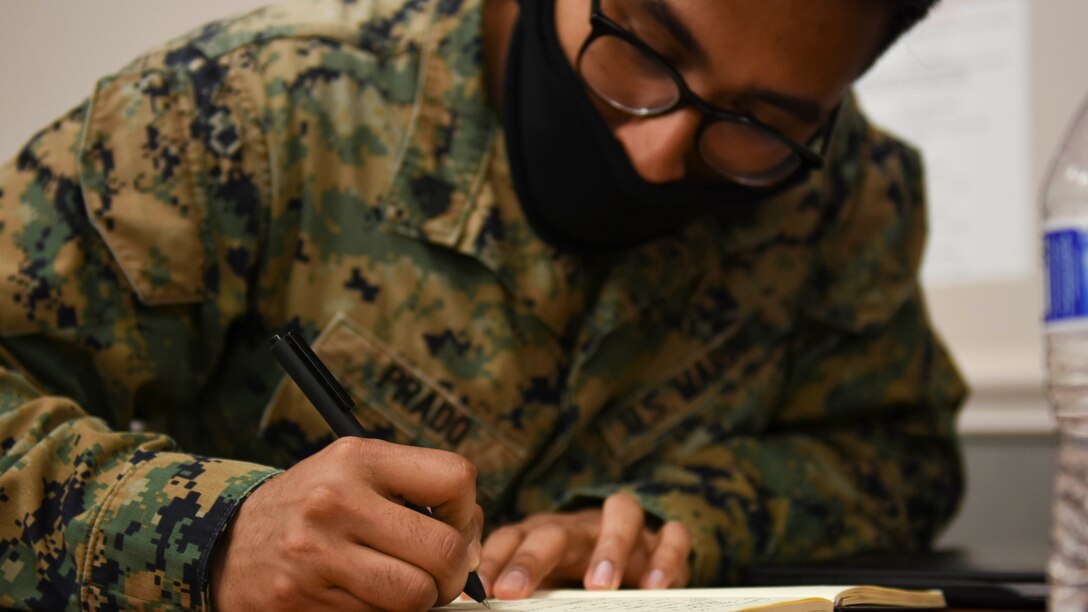 A DINFOS Marine takes class notes