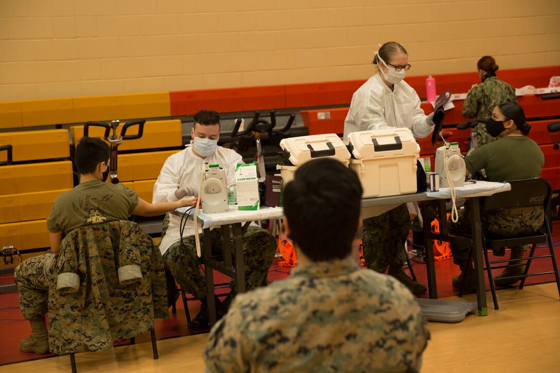 U.S. Marines wait their turn to donate blood during an Armed Services Blood Program (ASBP) blood drive at Hopkins Gymnasium on Camp Elmore, Norfolk, Virginia, May 28, 2020. Despite the Coronavirus Disease 2019 (COVID-19) pandemic, ASBP and leaders with Headquarters and Service Battalion, U.S. Marine Corps Forces Command, Fleet Marine Force Atlantic, coordinated this event to help support the ASBP in their critical mission of blood collection, manufacturing and transfusion of the U.S. military. (U.S. Marine Corps Photo by Lance Cpl. Jack Chen)